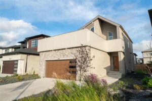 Former show home in Prairie Pointe with main-floor bedroom, spice kitchen and 24x24 garage at 345 Ken Oblik Drive, Winnipeg